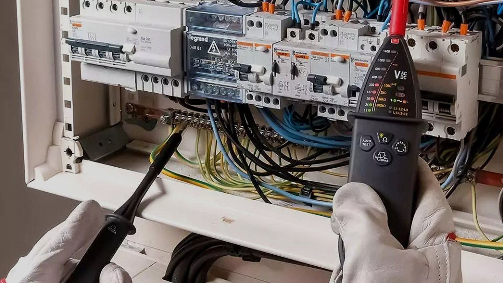 Electrician testing a DB box with voltage tester at night call-out