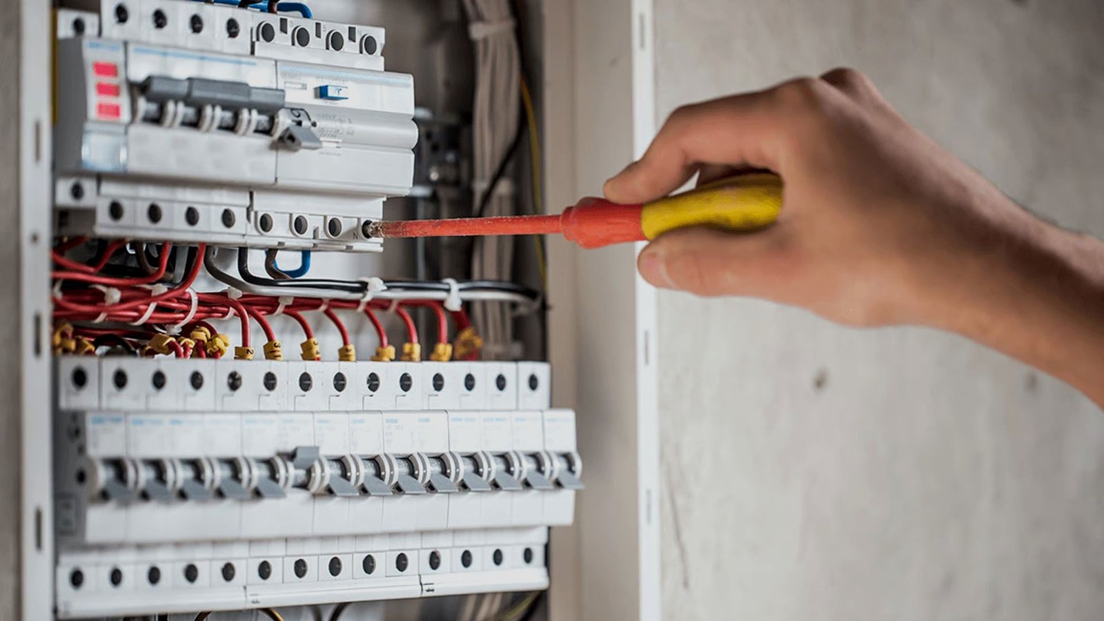 Electrician working inside a distribution board
